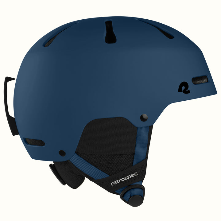 retrospec Comstock ski helmet in matte navy, side view showing adjustable dial and top vents.