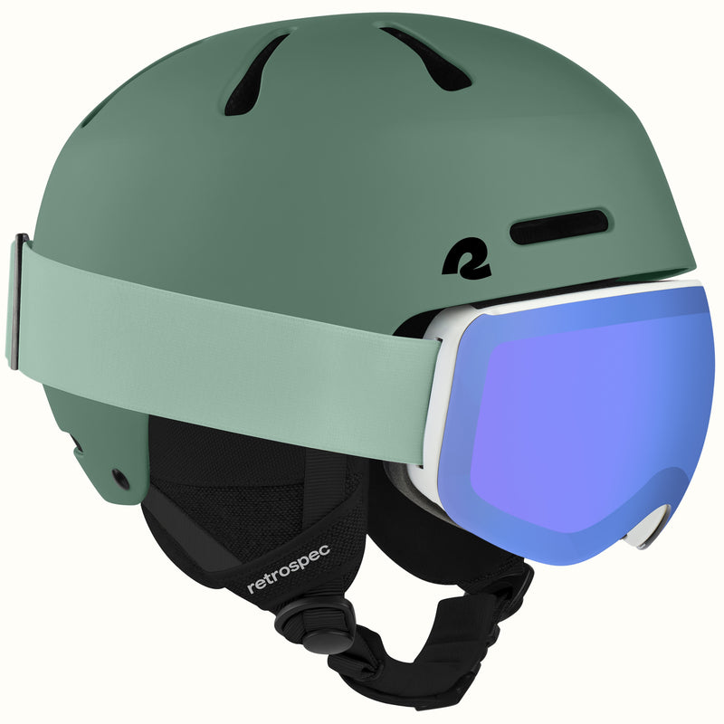 retrospec Comstock ski helmet with goggles in matte summit grove, blue mirrored lens goggles clipped to the strap.