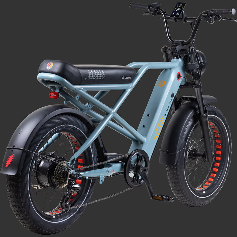 A rear view of the stylish blue Grateful Dead Valen Rev+ Electric Fat Tire Bike featuring a sleek frame with iconic Grateful Dead 60th Anniversary Artwork, and a digital display on the handlebars.