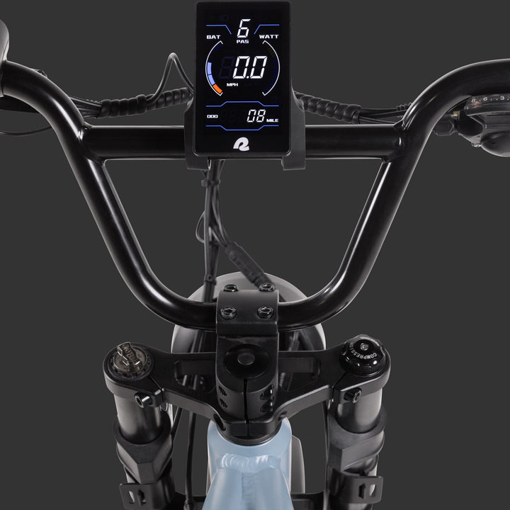 Close-up view of the Grateful Dead Valen Rev+ Electric Fat Tire Bike's handlebars featuring a digital display showing battery status, power assist level, speed, and distance metrics.