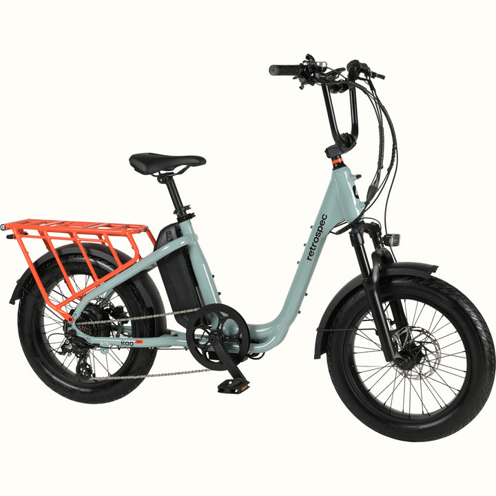 Mint green electric bike with a cargo rack on a white background.