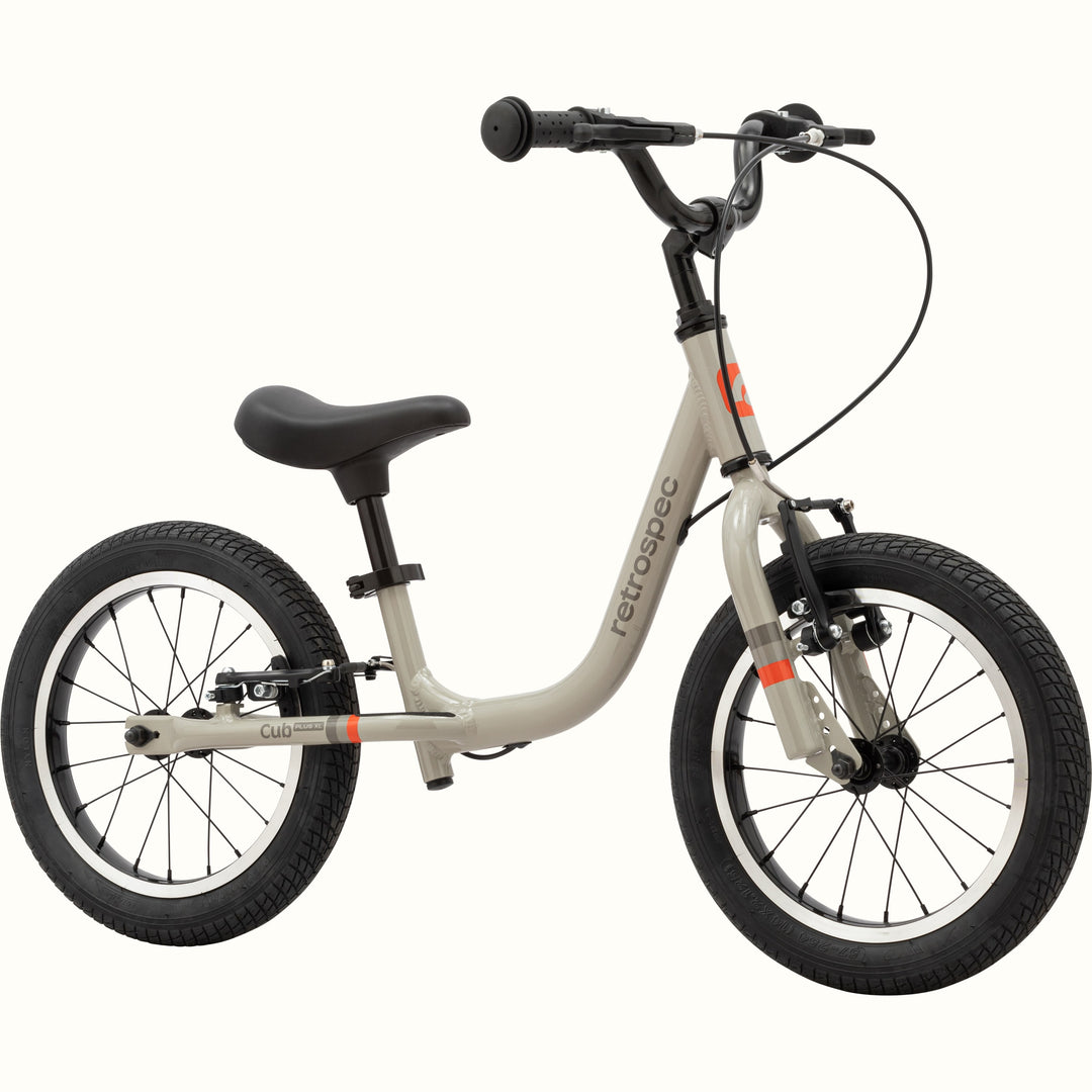 Gray balance bike with black details on a white background.