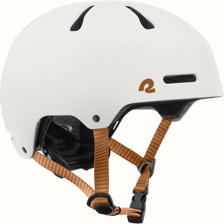 A white skate helmet with black vents, a brown logo on the side, and brown adjustable chin straps, shown against a plain white background.