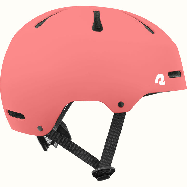 Side profile of the retrospec Dakota pink bike helmet for kids with a matte finish, vents, and black side straps.