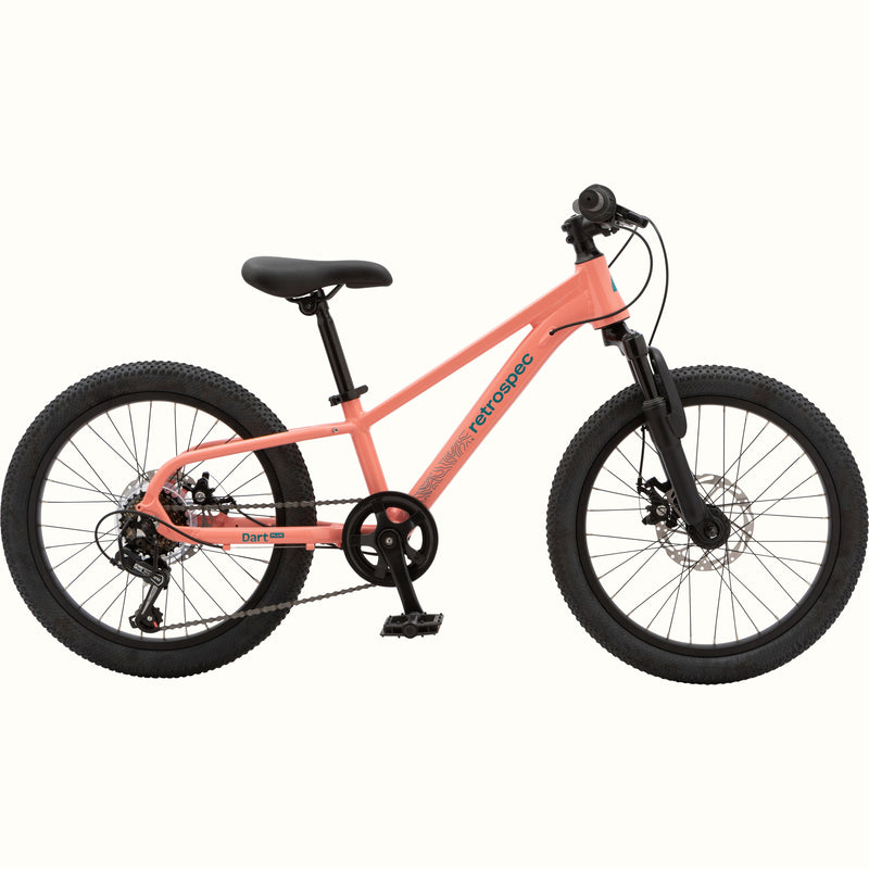 Profile view of the Dart Plus 20" Kids' Bike in Fairy Floss Salmon color with blue-gray branded "retrospec" and "Dart Plus" logos on the frame, and thick black tires isolated on a white background.