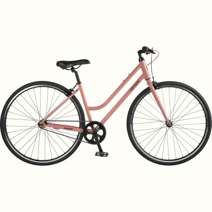 A pink single-speed fixie bicycle with black wheels on a white background.