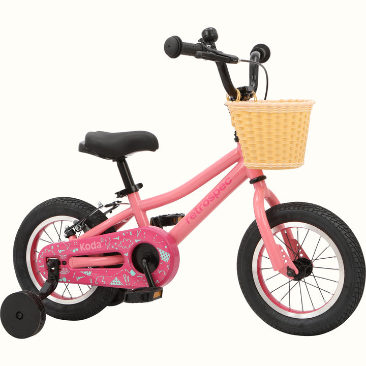 Children's pink bicycle with training wheels and a front basket.