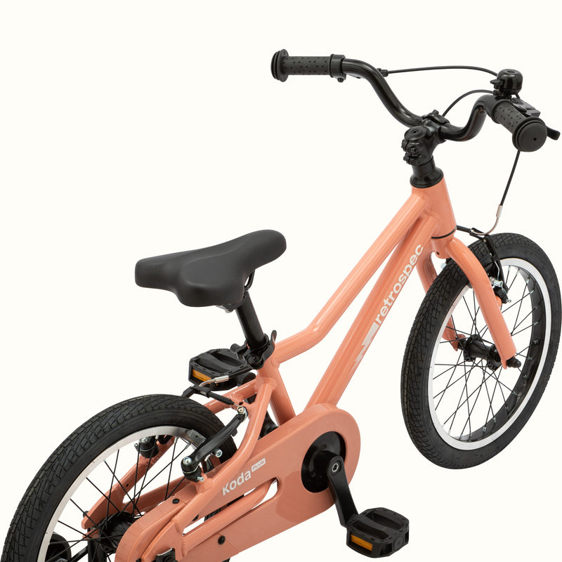 A Rose pink kids' Koda Plus 16" bicycle with training wheels, isolated on a white background.