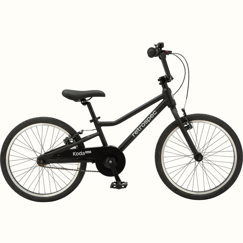 A matte black Koda Plus 20" Kids' Bike with black chain guard, seat and wheels.