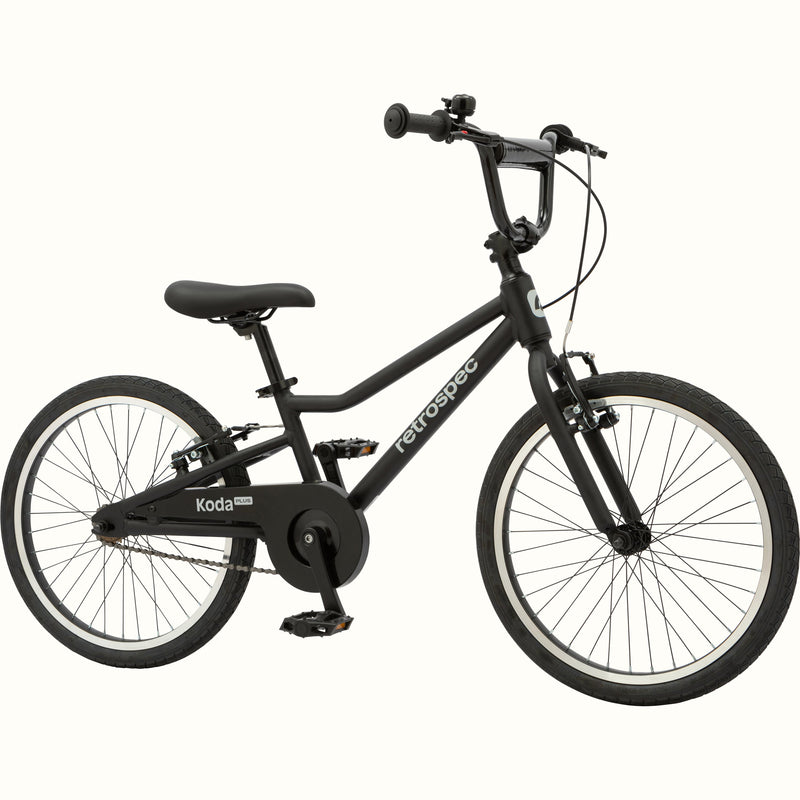 Matte black kids' Koda Plus 20" Bike with black chain guard and black saddle on a white background.
