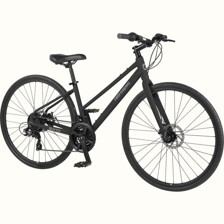 Angled view of the retrospec Martis commuter bike in Matte Black with a front disc brake and padded saddle.