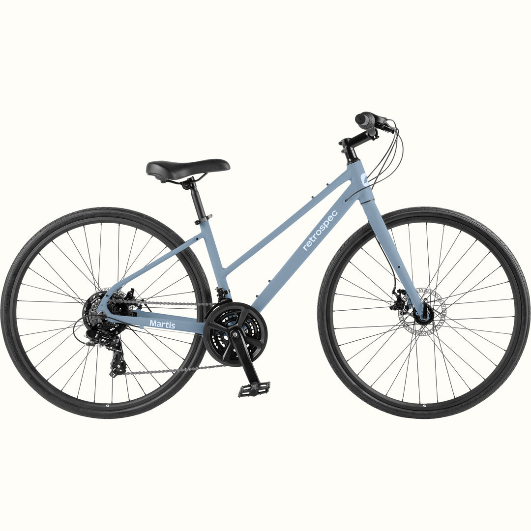 Side profile of the retrospec Martis hybrid bike in Matte Fog, a soft blue gray frame with disc brakes.