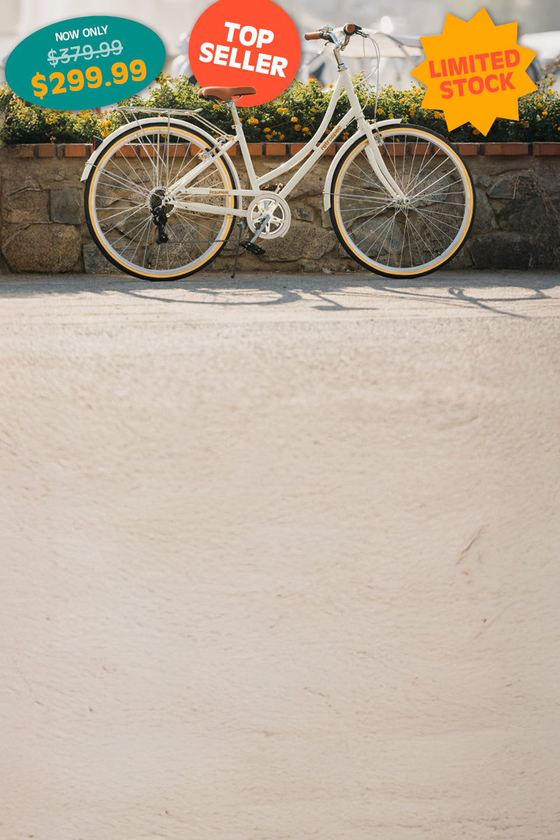 White retro-style bicycle displayed outdoors with price tags indicating a discounted $299.99 sale, labeled as top seller and limited stock.
