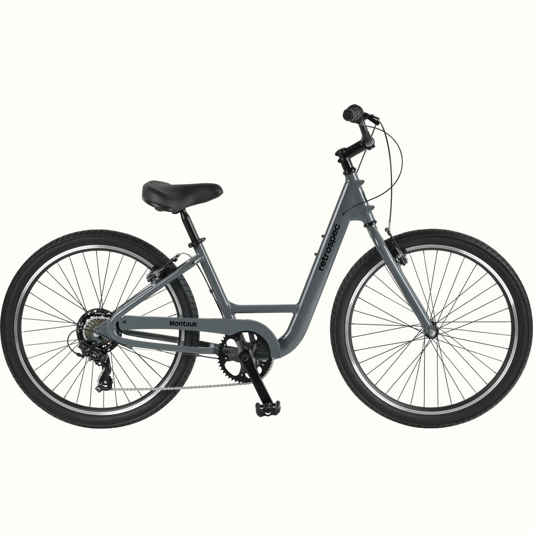 retrospec Montauk 26-inch 7-speed step-through cruiser bike in graphite gray with black tires, saddle, and upright handlebars, shown on a clean white background.