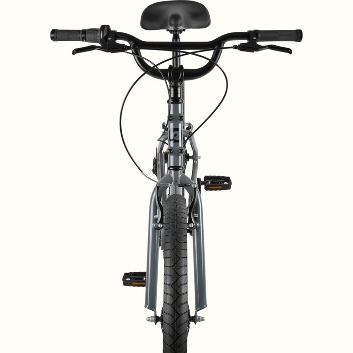 Front view of the retrospec Montauk 26 7-speed cruiser bike in graphite gray, highlighting the wide black handlebars with brake levers, black saddle, front brake caliper, and treaded front tire.