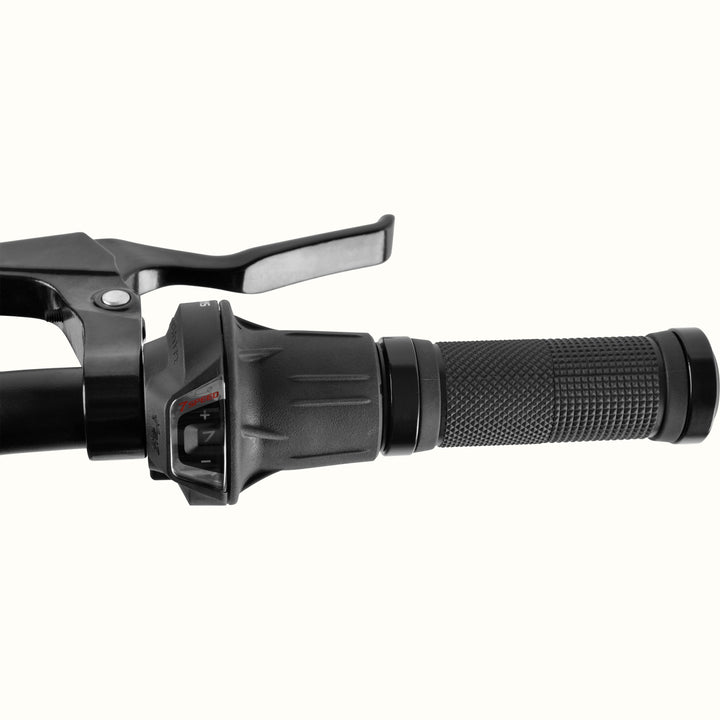 Close-up of the retrospec Montauk 26 7-speed bike's handlebar, showing the twist-grip shifter, brake lever, and textured rubber grip.