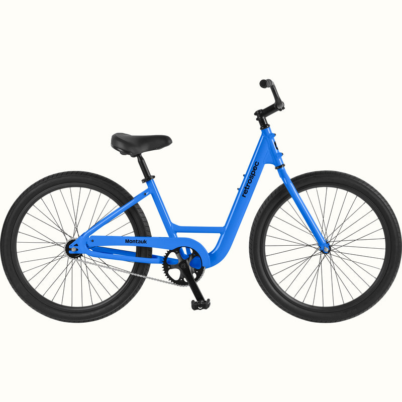 retrospec Montauk cruiser bike in cobalt blue with a low step-through frame, black tires, saddle, and upright handlebars, shown on a clean white background.