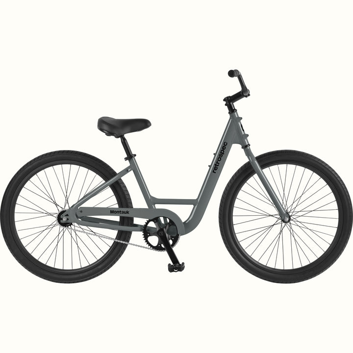 retrospec Montauk cruiser bike in graphite with a low step-through frame, black tires, saddle, and upright handlebars, shown on a clean white background.