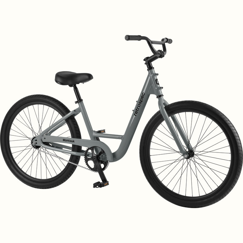 retrospec Montauk cruiser bike in graphite with a low step-through frame, black tires, saddle, and upright handlebars, shown on a clean white background.