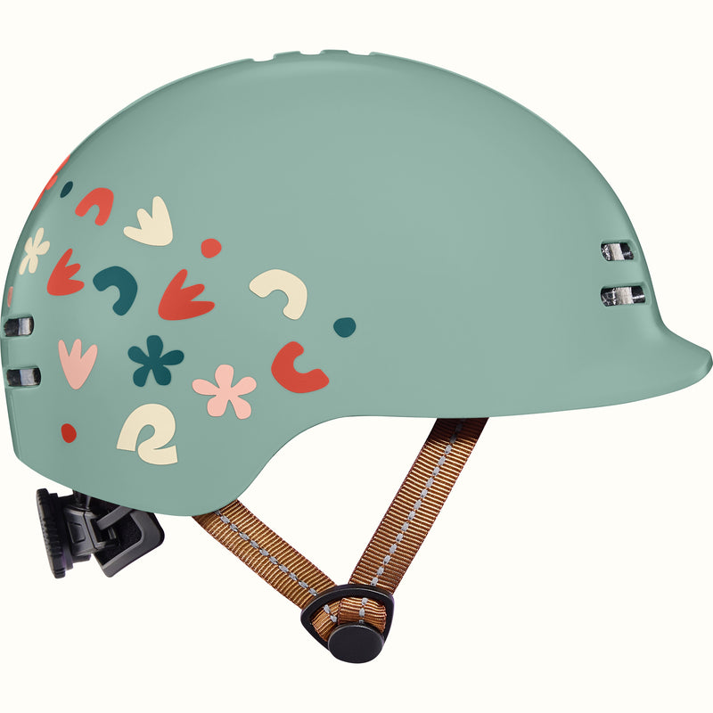 Light green toddler bike helmet with colorful graphics and a brown strap on a white background.