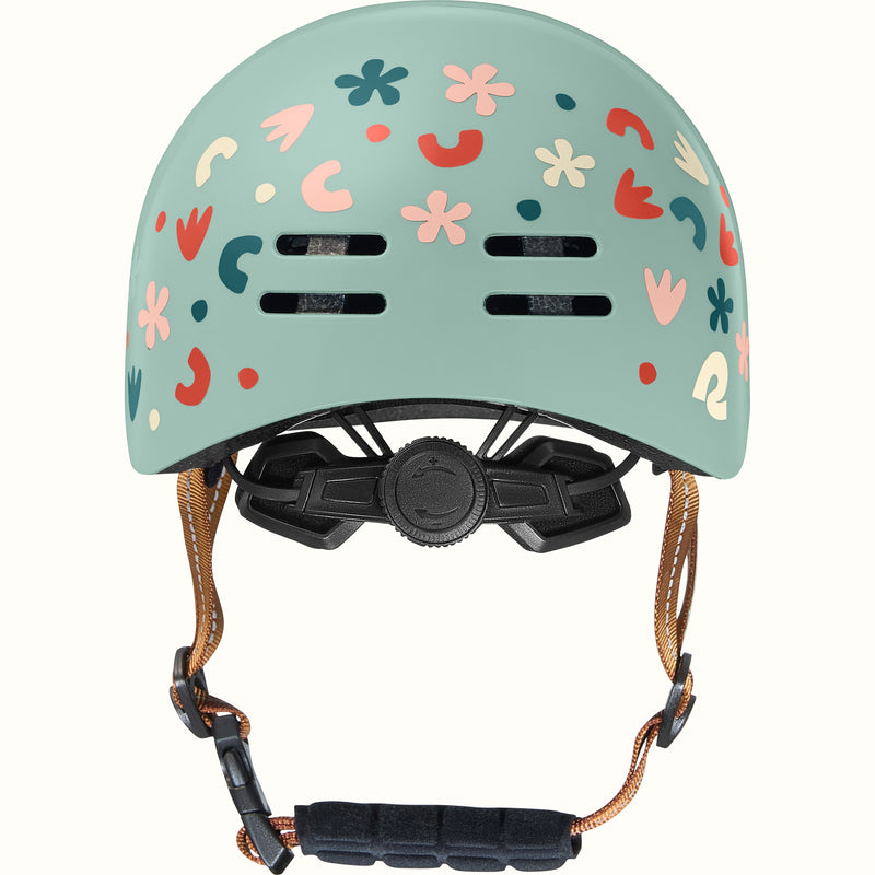 Light green toddler bike helmet with colorful graphics and a brown strap on a white background.