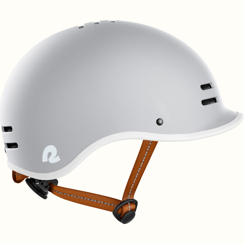 Gray bike helmet with adjustable brown straps, featuring ventilation holes and a stylish logo on the side.