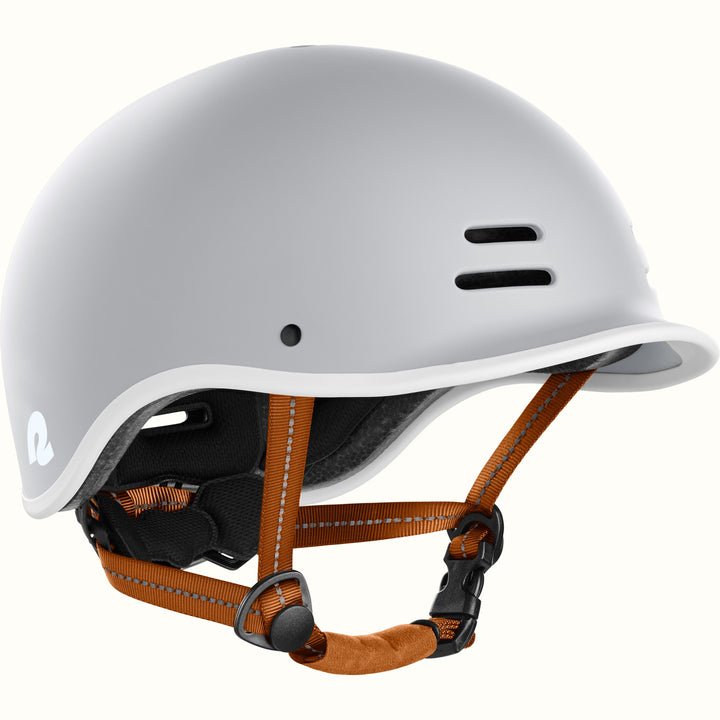 Gray bike helmet with adjustable brown straps, featuring ventilation holes and a stylish logo on the side.