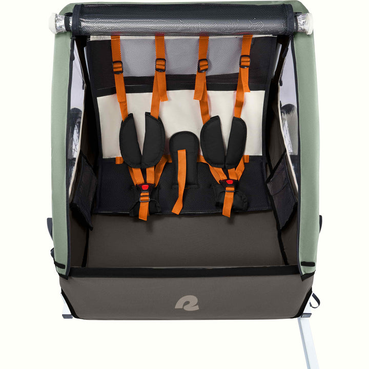 A Rover Plus Child Double bike trailer with a mesh front, featuring orange harness straps and a sturdy frame, designed for safety and comfort.