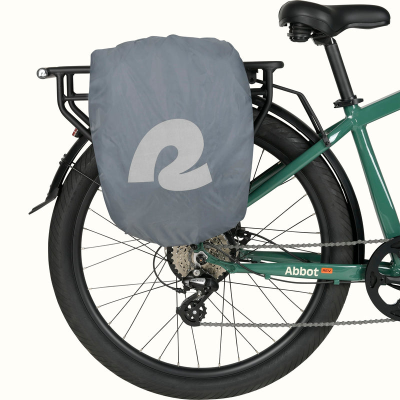 Sidekick Duo Saddle Bag concealed with rain cover while mounted on a green retrospec Abbott Rev EBike's rear rack.