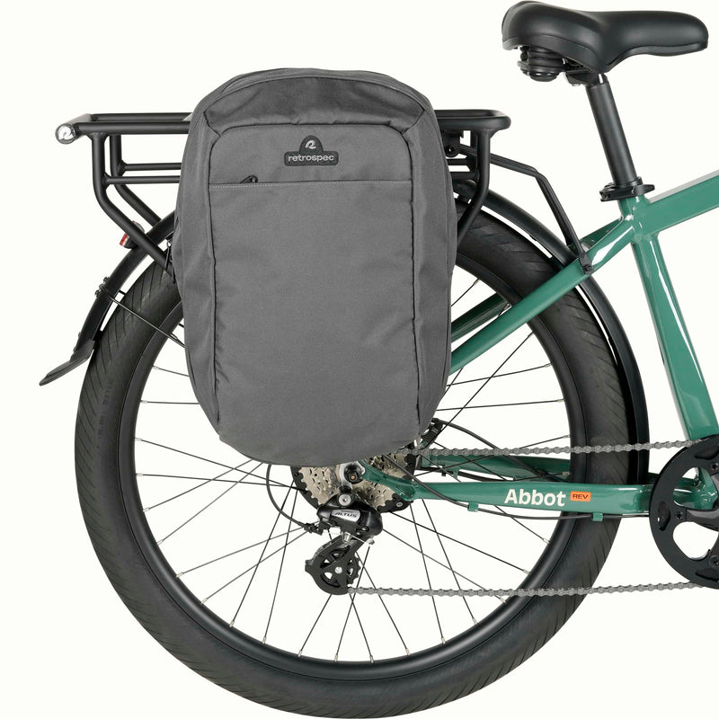 A gray pannier bag attached to the rear rack of a green Abbot Rev Electric Bicycle.