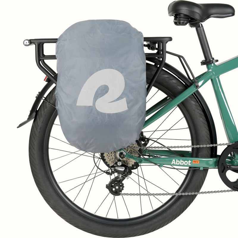 Green Abbot Rev EBike with a pannier attached which has a gray rain cover displaying a retrospec logo, mounted on a rear rack.