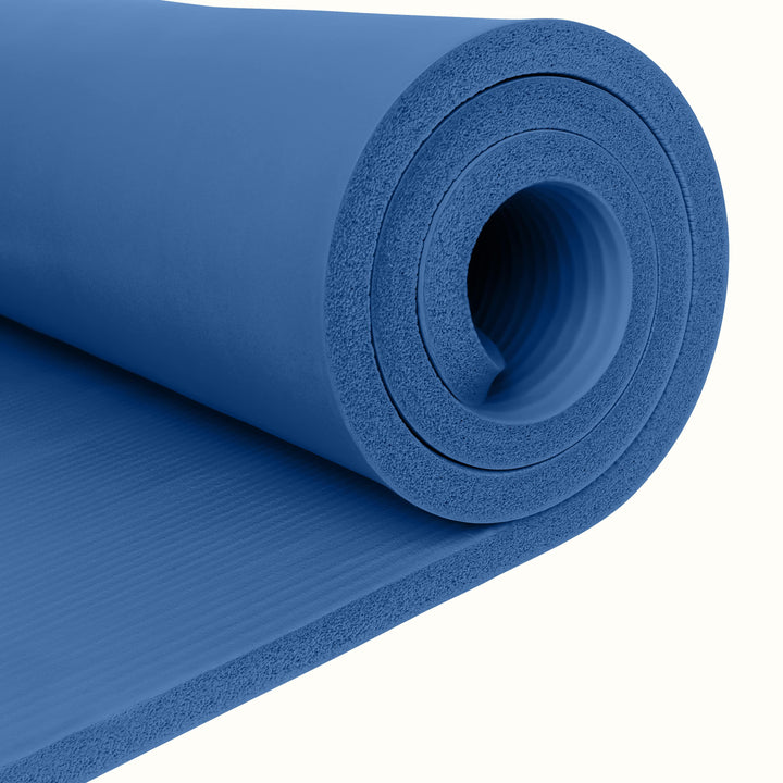 Close-up of a blue Solana 1" Yoga Mat rolled up on a white background.