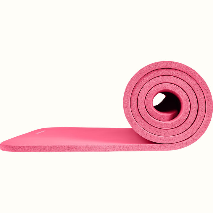 Pink Solana .5" Yoga Mat rolled up on a white background.