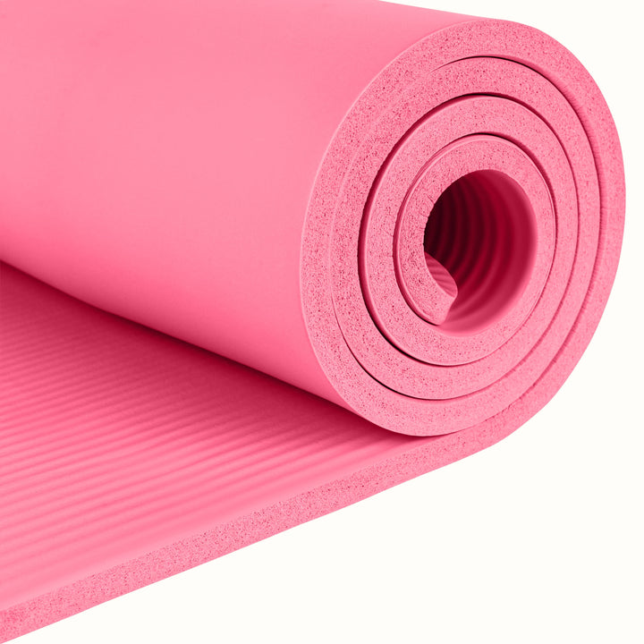 Close-up of the pink Solana .5" Yoga Mat rolled up on a white background.