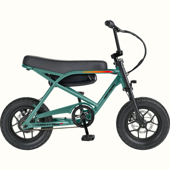 A compact electric mini bike with a green frame, black seat, black tires, and black handlebars, shown from a side profile on a solid white background. The brand names 'retrospec' and 'Valen Rev' are visible on the frame.