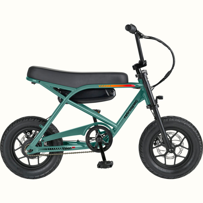 A compact electric mini bike with a green frame, black seat, black tires, and black handlebars, shown from a side profile on a solid white background. The brand names 'retrospec' and 'Valen Rev' are visible on the frame.