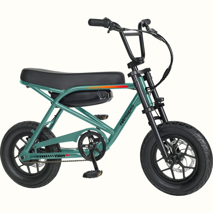 A mini electric bicycle with a green frame, black seat and tires, and a black battery pack mounted on the rear frame, shown against a plain white background.