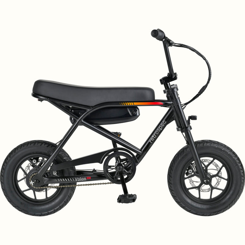 A compact electric mini bike with a black frame, black seat, black tires, and black handlebars, shown from a side profile on a solid white background. The brand names 'retrospec' and 'Valen Rev' are visible on the frame.