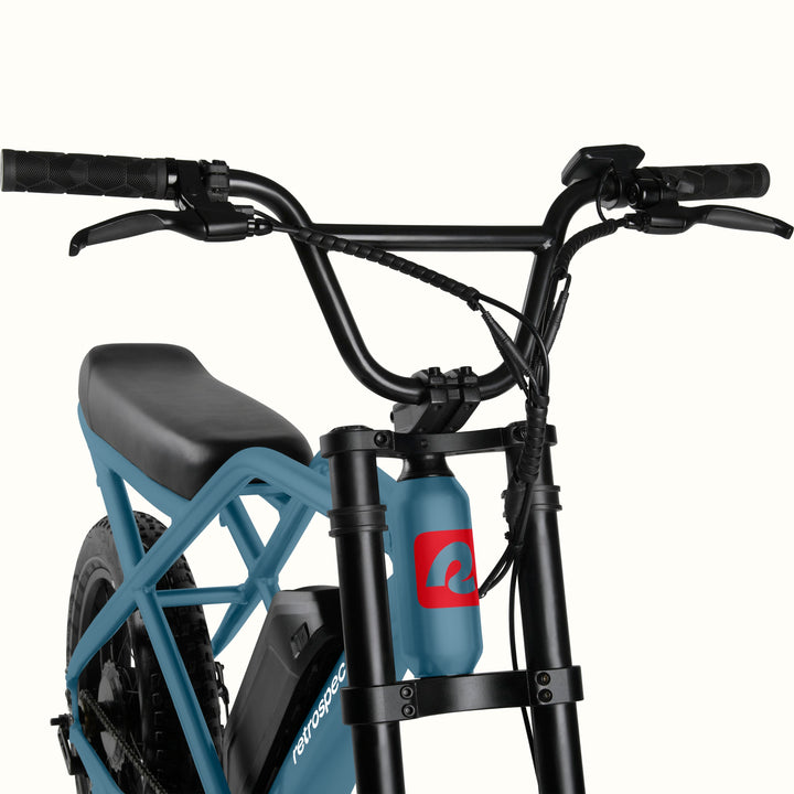 Close-up of Blue Valen Rev 3 Fat Tire Electric Bike with black seat on a white background.