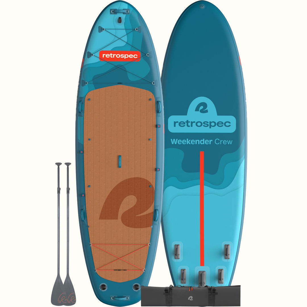 The front and back of the Weekender Crew Multi-Person Inflatable Stand Up Paddle Board 12’ in blue with red accents and shown with two paddles and a dark grey carry bag.