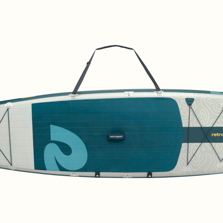 A dark gray padded should strap attached to a Paddleboard with a blue and gray design on a white background.