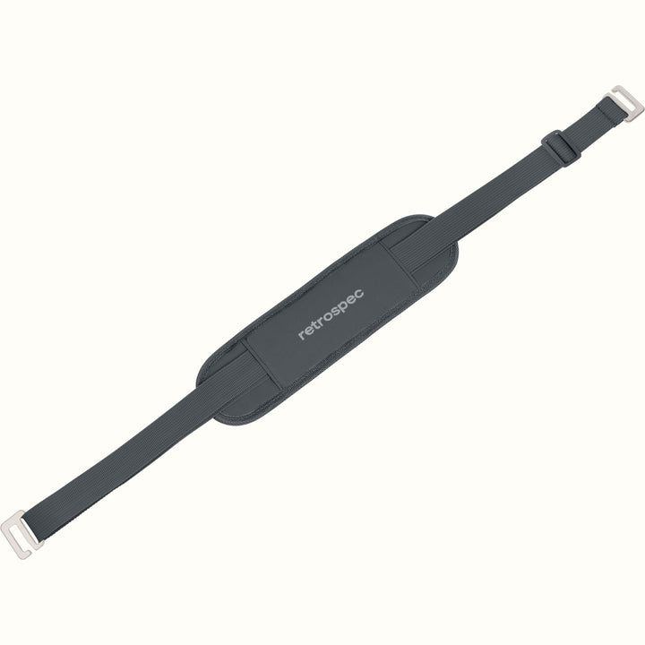 A dark gray padded shoulder strap designed for carrying paddle boards, with the brand 'retrospec' visible on the strap's padding.