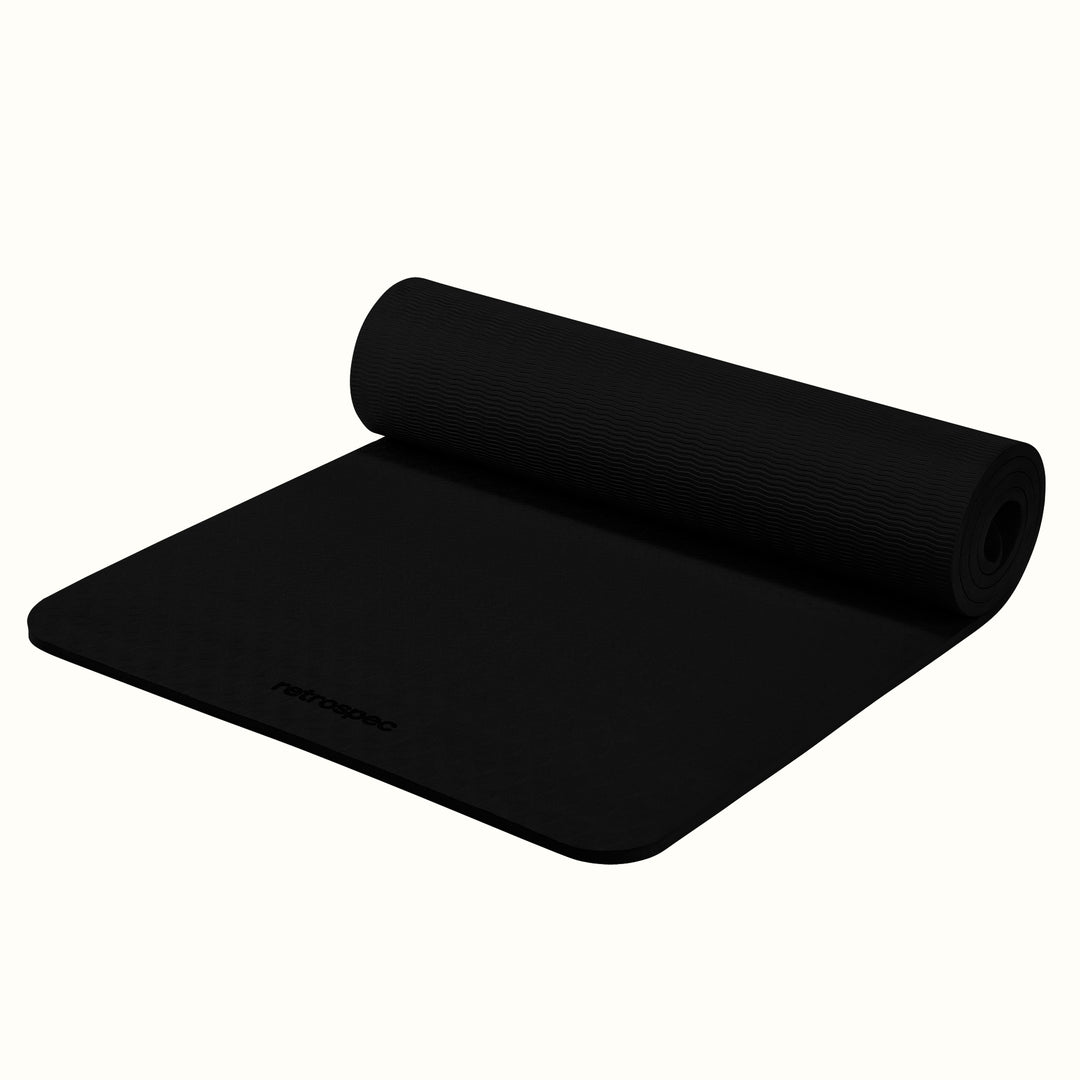 Partially rolled out black Zuma Yoga Mat with textured surface on a white background.