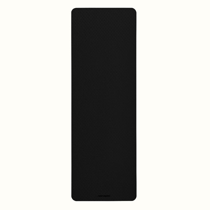Black Zuma Yoga Mat with textured surface on a white background.