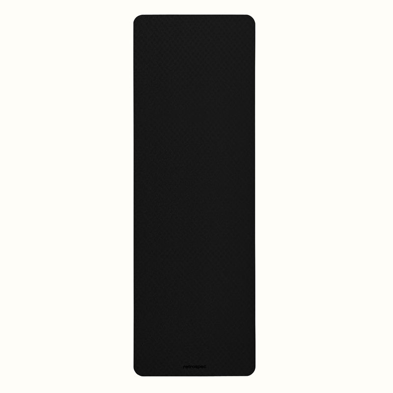 Black Zuma Yoga Mat with textured surface on a white background.