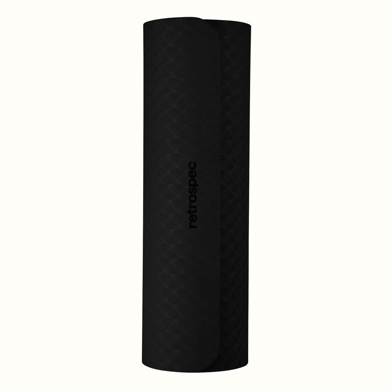 Rolled up black Zuma Yoga Mat with textured surface on a white background.