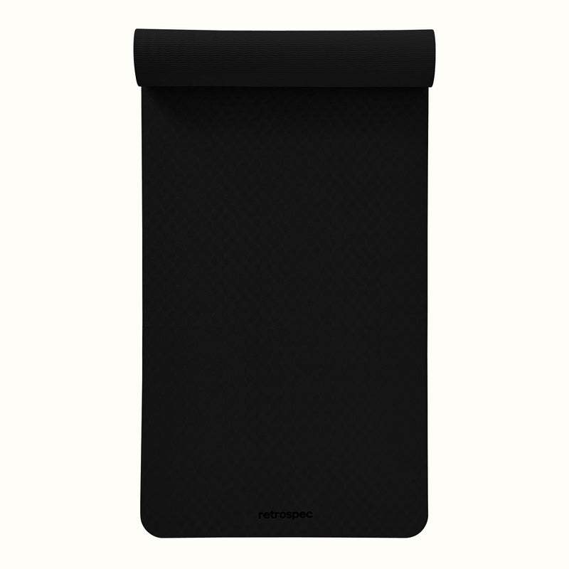 Partially rolled out black Zuma Yoga Mat with textured surface on a white background.