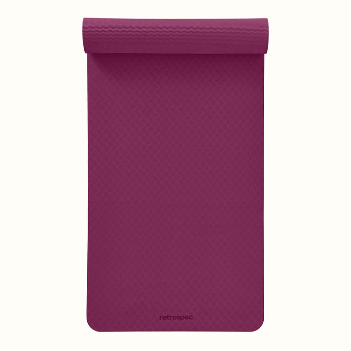 Partially rolled out Boysenberry Zuma Yoga Mat with textured surface on a white background.