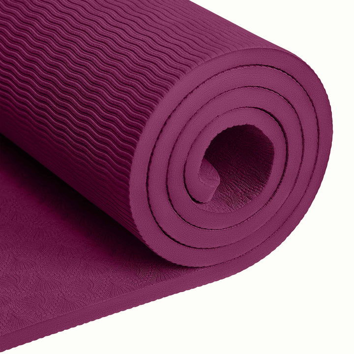 Close-up of a tightly rolled Boysenberry textured Zuma Yoga Mat with wavy patterned surface on a white background.