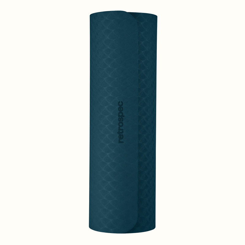 Rolled up Ocean Blue Zuma Yoga Mat with textured surface on a white background.